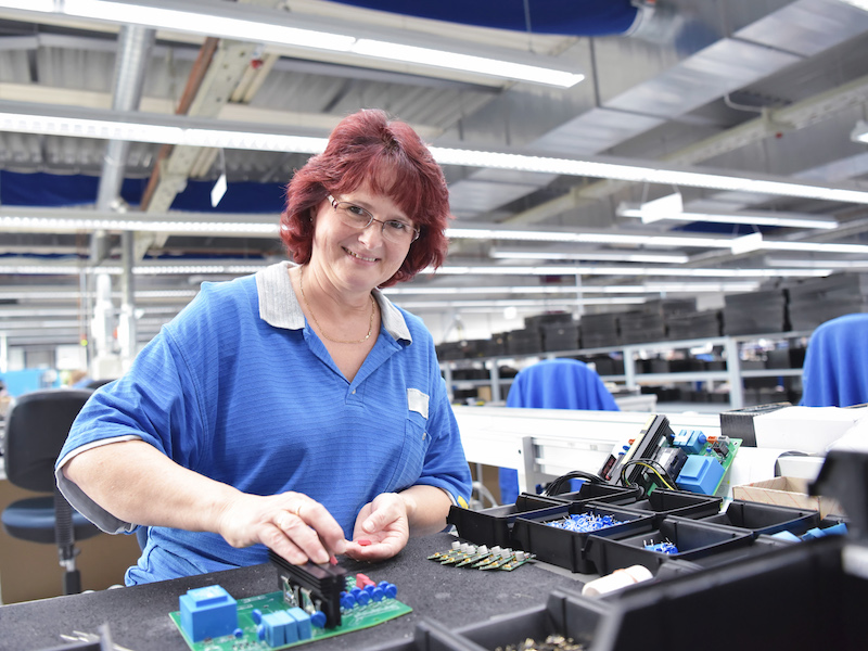 Person assembling components in a microelectronics factory