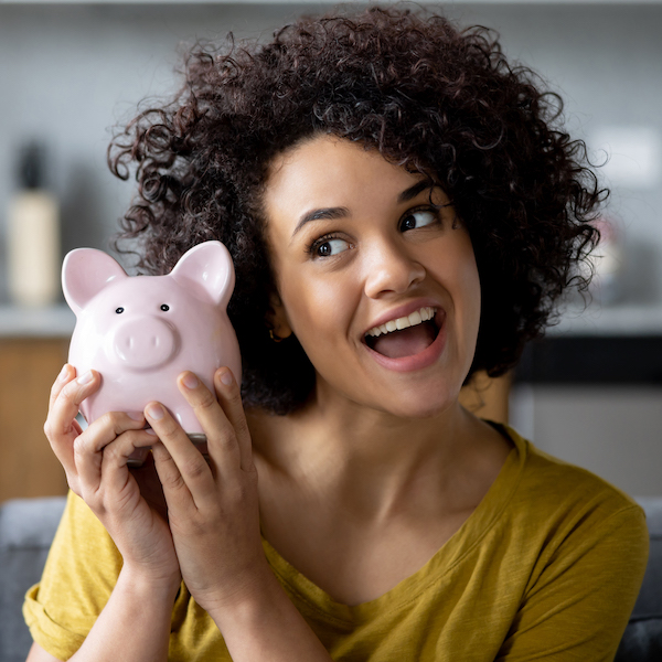 Happy person holding piggy bank